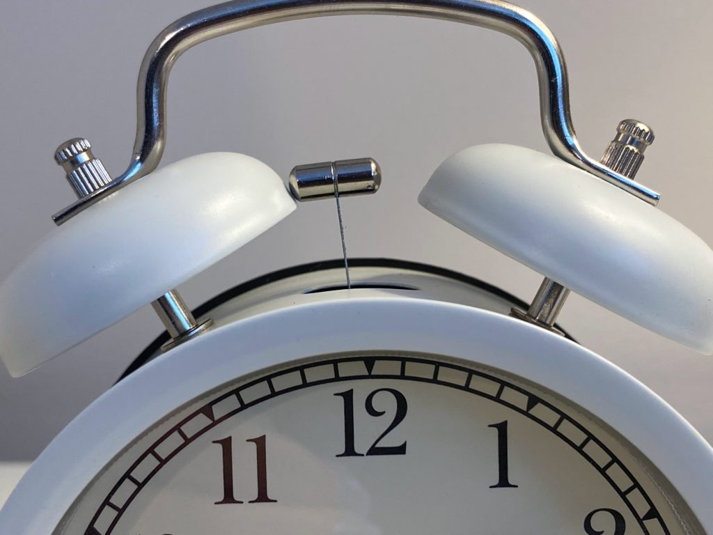 Stock image of the top of an old-fashioned, white alarm clock.